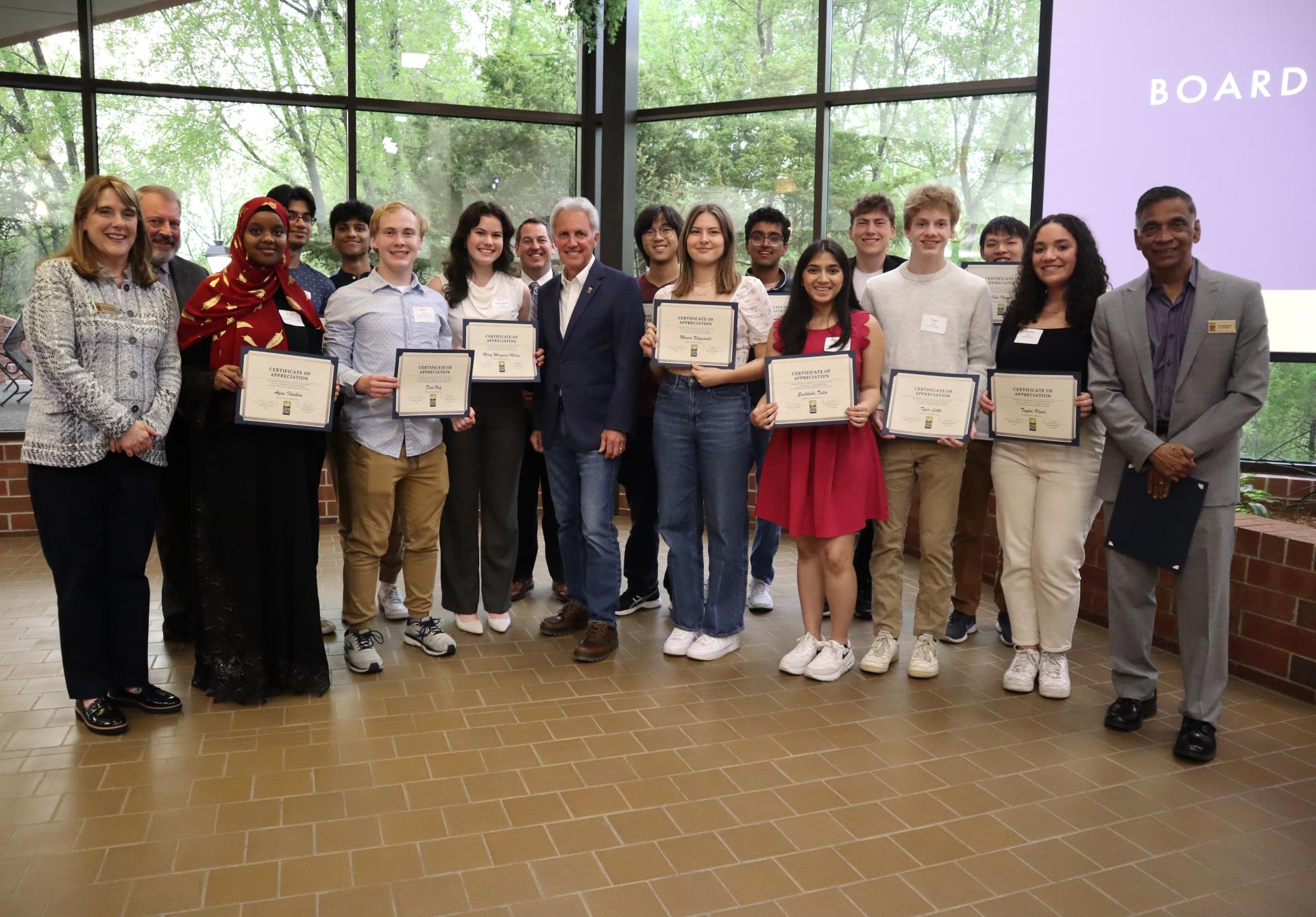 Large group of students posing for a photo with Council Members, Mayor and school district Superintendent