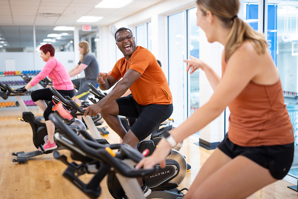 Close up photo of two people on bikes, pointing at one another