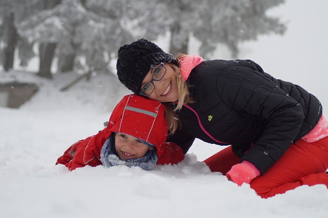Mom kneeling with child in snow